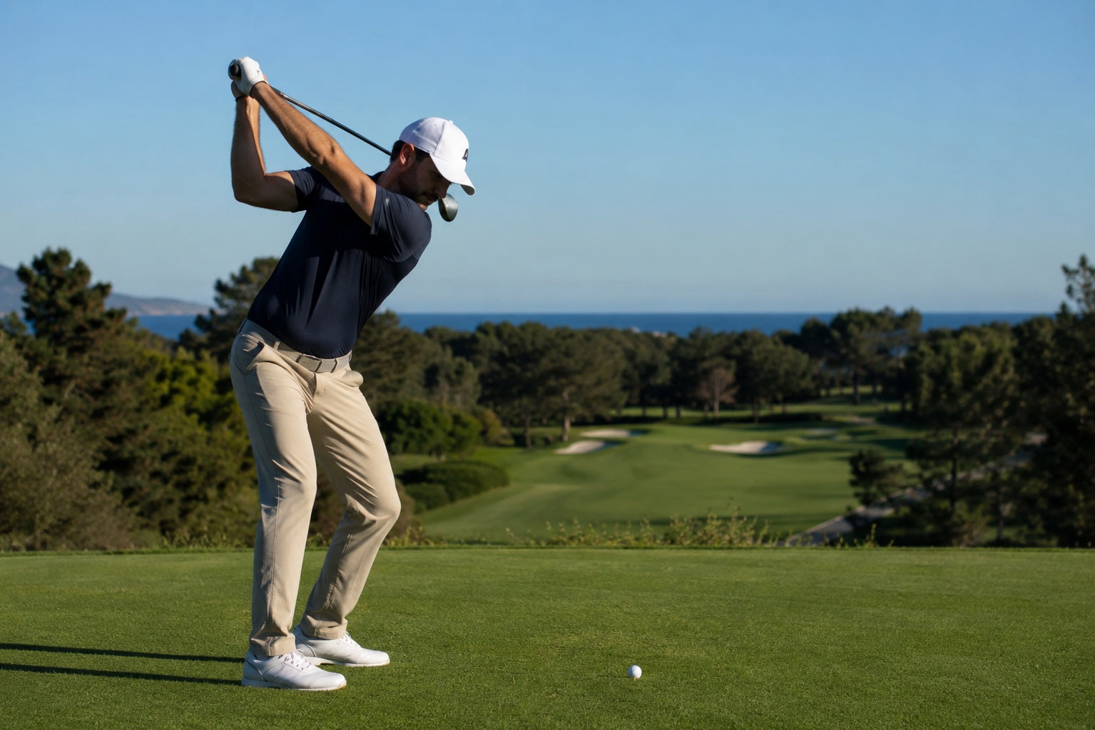 Golfer with club over shoulders on a sunny course